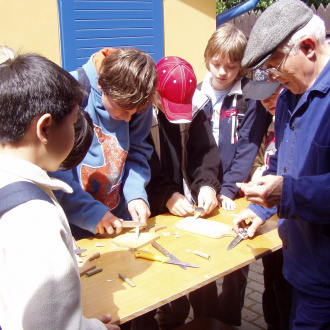 František Zuska učí děti dělat píšťalky z vrbových prutů (Malenovice - hájenka, 2014