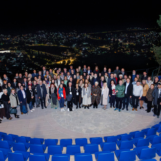 Účastníci konference na společné fotografii na vyhlídce nad nočním Trebinje.
